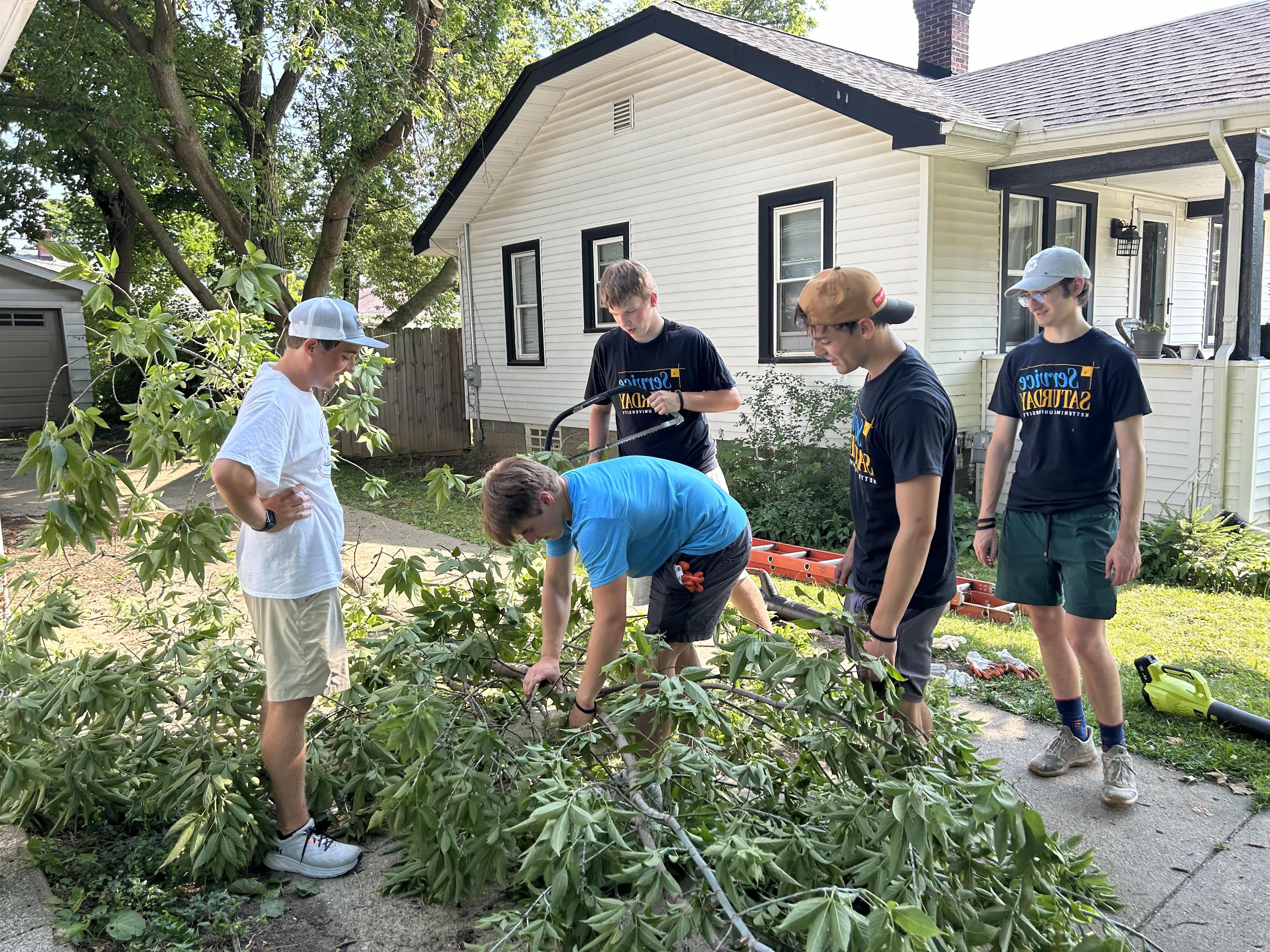 Students cutting down trees on Service Saturday