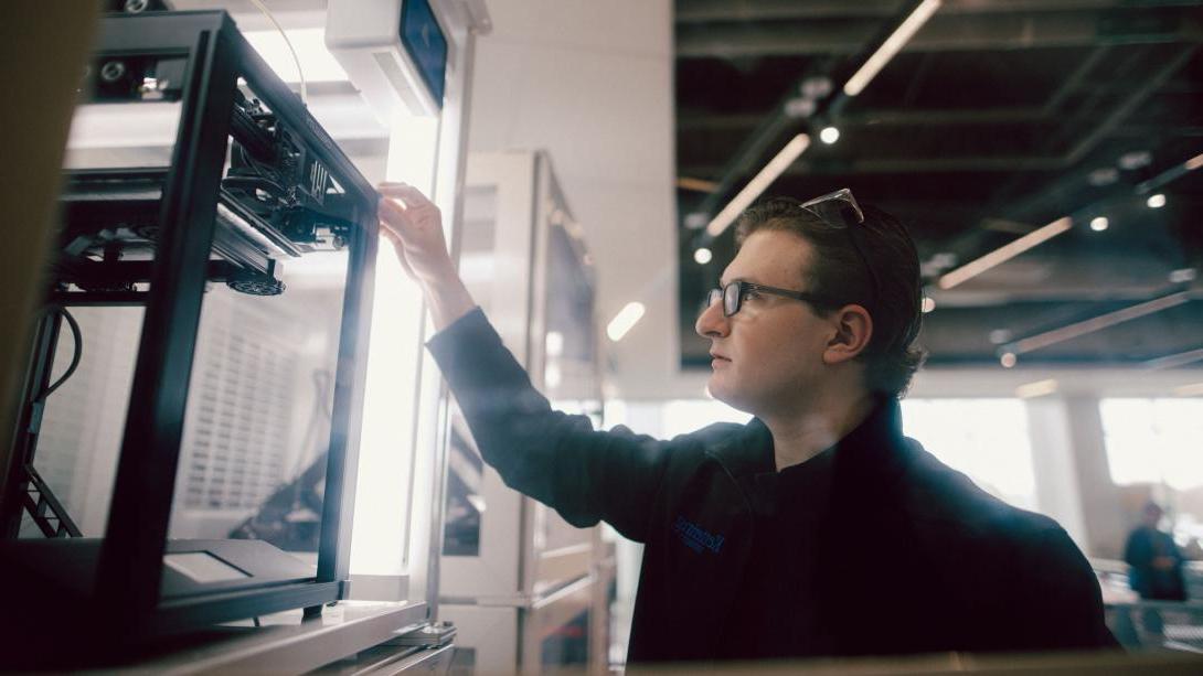 A Kettering student uses a 3D printer in the Makerspace