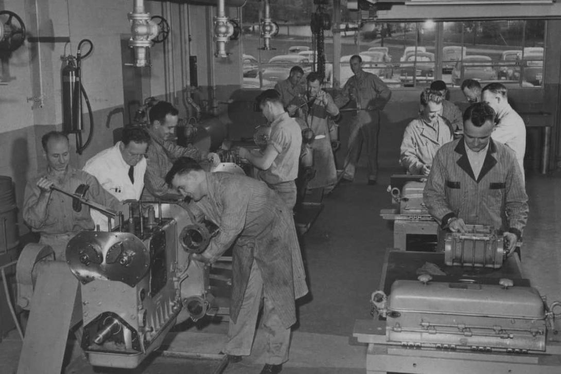 A black-and-white photo from the 1950s-1970s of Kettering students working on car parts in an automotive garage